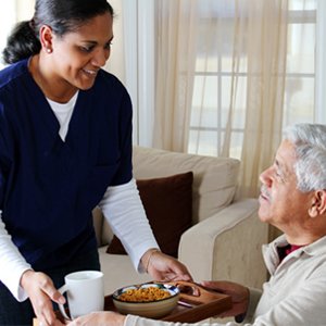 caregiver serving elderly people food