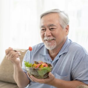 Older man eating veggies