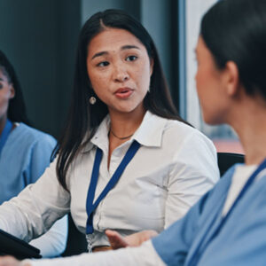 Healthcare professionals having a focused conversation during a team meeting.