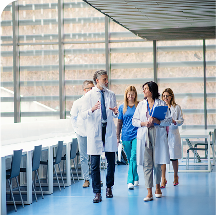 Healthcare professionals walking together and discussing patient care in a clinical facility