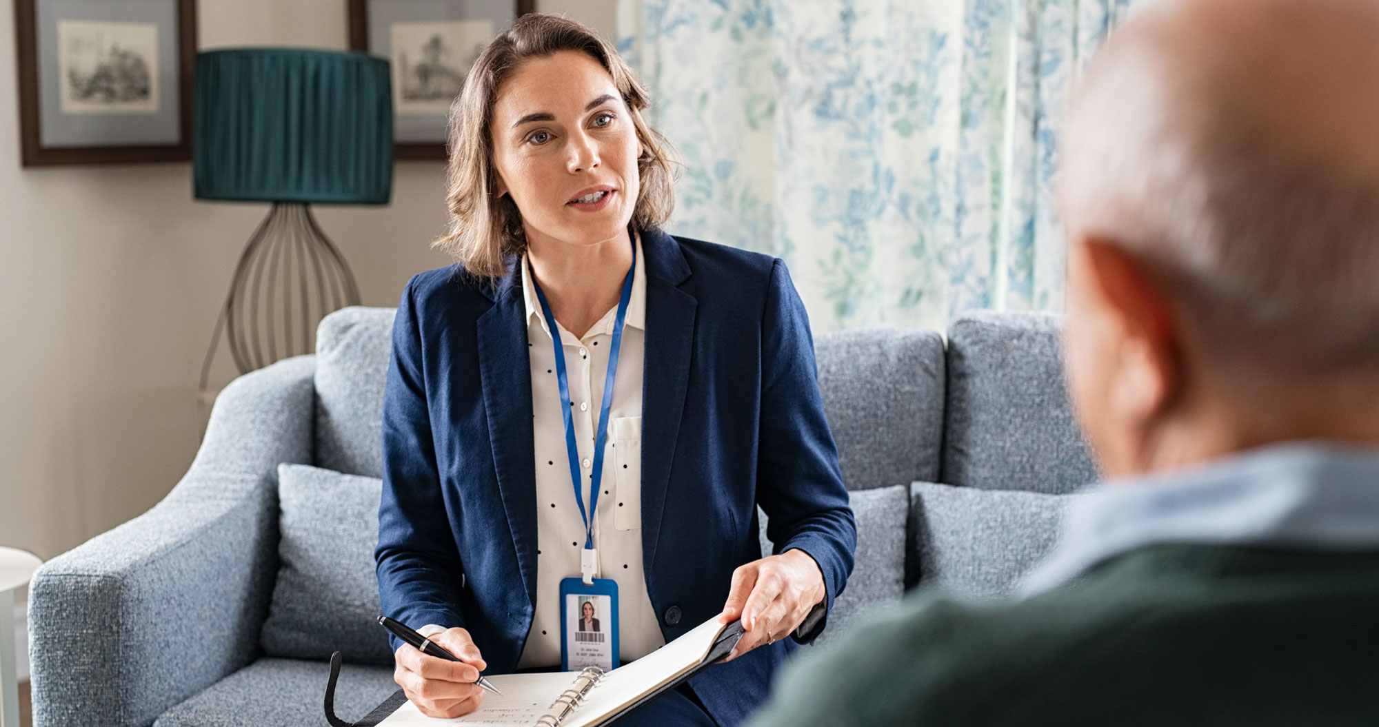 Licensed social worker meeting with older adult client during in-home assessment, representing social work continuing education and professional practice