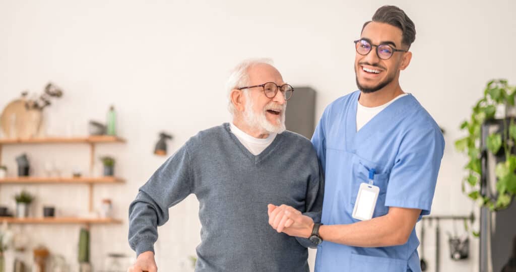 Florida CNA assisting older adult patient with mobility in home care setting, representing certified nursing assistant continuing education and renewal training.
