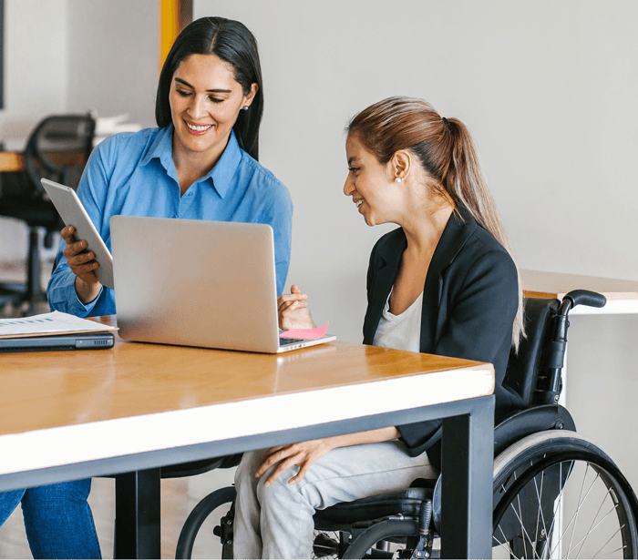 Certified Rehabilitation Counselor supporting a wheelchair user during a vocational rehabilitation consultation.