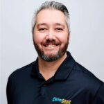 Clinton Nemmer in front of a grey backdrop wearing a CareerSmart polo