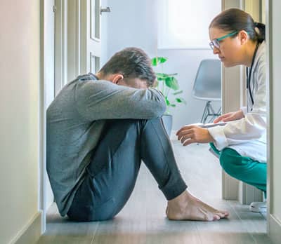 Healthcare professional supporting a distressed patient during a mental health crisis and suicide prevention intervention.