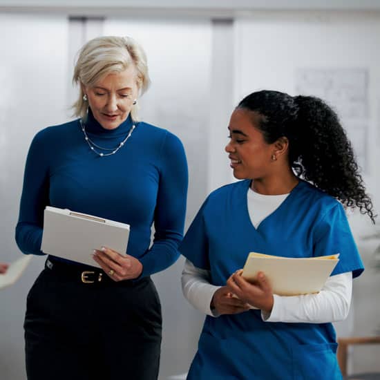 Case manager and nurse reviewing patient information together during discharge planning.