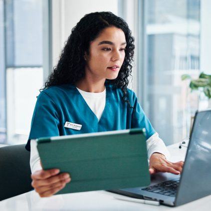 Woman, nurse or reading with laptop or tablet for medical research, discovery or study at hospital. Female person, healthcare worker or employee with technology for telehealth or health app at clinic