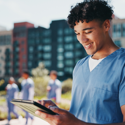 Public health professional using a tablet outdoors on a healthcare campus